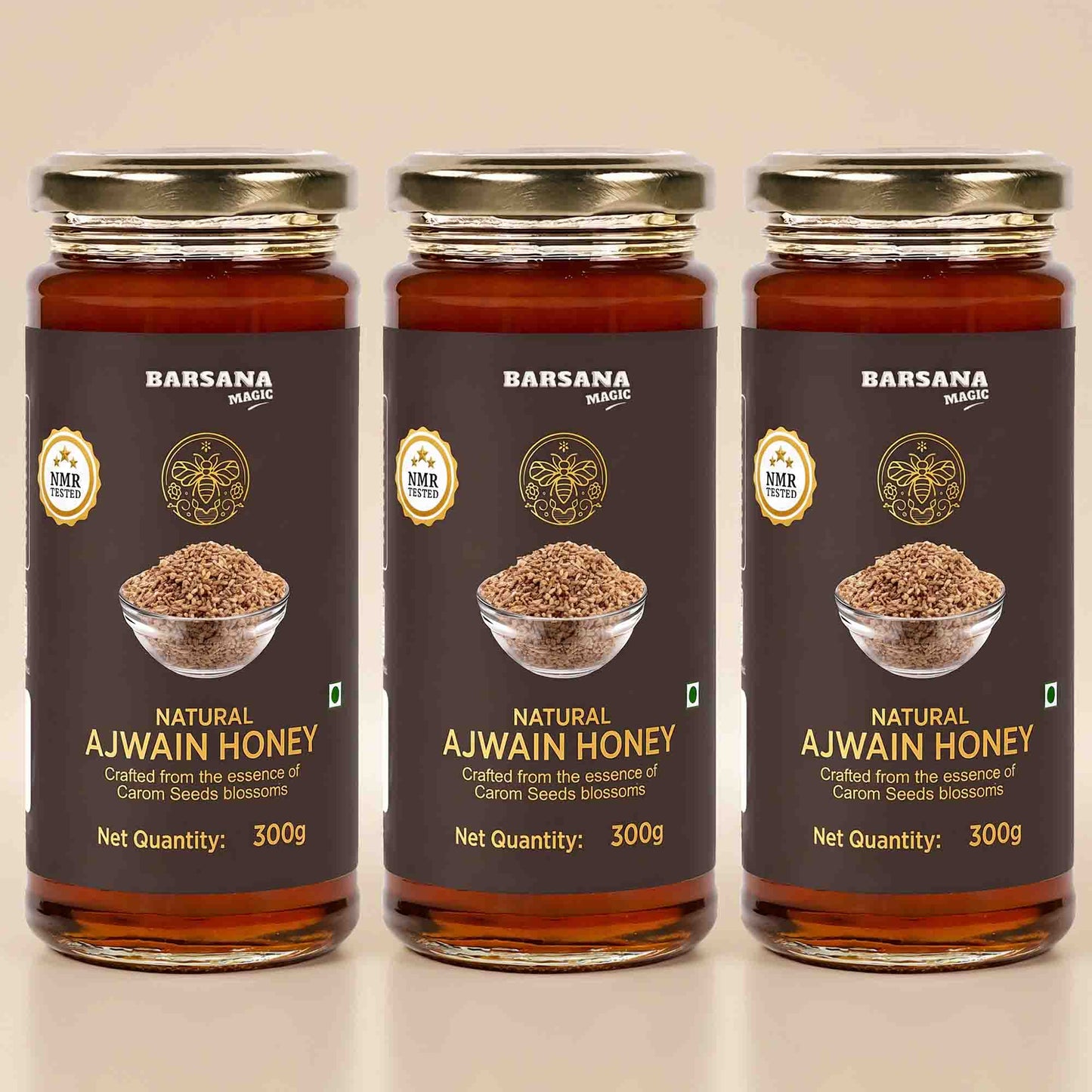 Barsana Magic and Three glass jars of Barsana Natural Ajwain Honey arranged side by side on a light beige background. Each jar has a dark brown label with gold lettering, a photo of ajwain seeds in a bowl, and a gold cap.