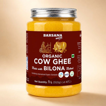 Barsana Magic and A 1-liter glass jar of Barsana Magic Organic Cow Ghee, filled with yellow ghee and featuring a dark red label with a silver metal lid, set against a solid beige background.