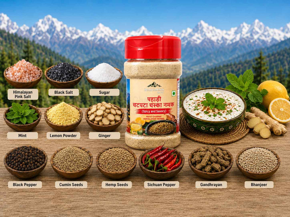 Barsana Magic and A jar of Punjabi Bhindi Bhara Masala spice mix displayed on a wooden surface with a scenic mountain backdrop. The jar is surrounded by labeled bowls of its ingredients, including Himalayan pink salt, black salt, sugar, mint, lemon powder, ginger, black pepper, cumin seeds, hemp seeds, Sichuan pepper, gandhwan, and bharjee.