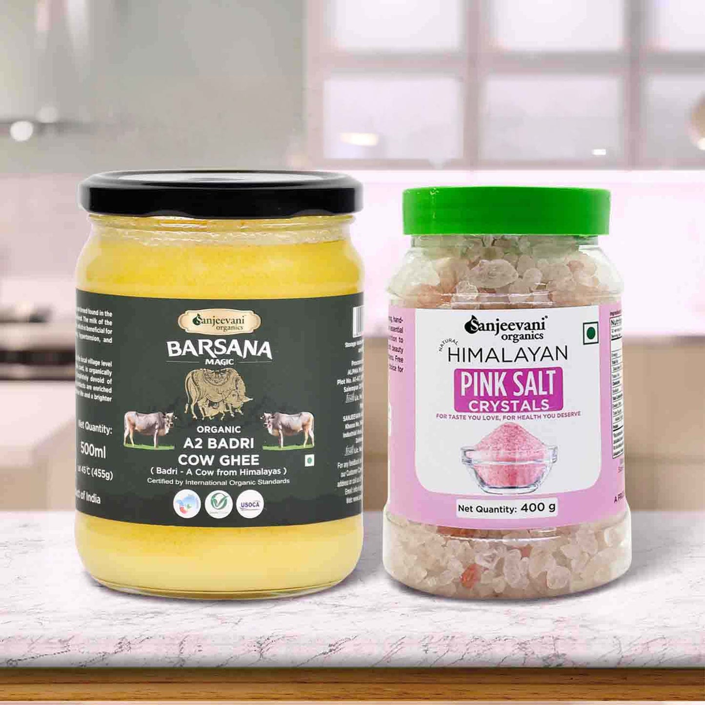 Barsana Magic and Two jars of cow ghee and Sanjeevani Himalayan pink salt crystals on a kitchen counter.