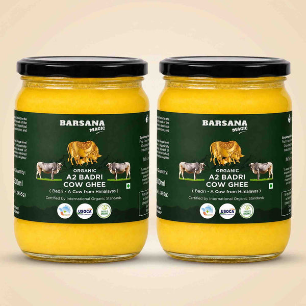 Barsana Magic and Two glass jars of A2 Badri Cow Ghee with black lids and dark green labels, displayed side-by-side on a light beige background.