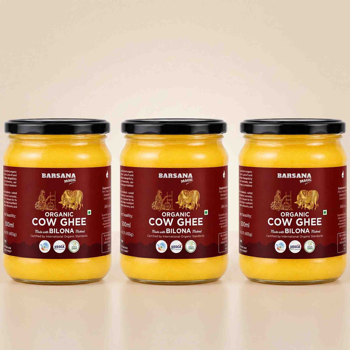 Barsana Magic and Three glass jars of Barsana Organic Cow Ghee (Rashmi and Bilona flavor) arranged side-by-side on a light beige reflective surface against a matching beige background.