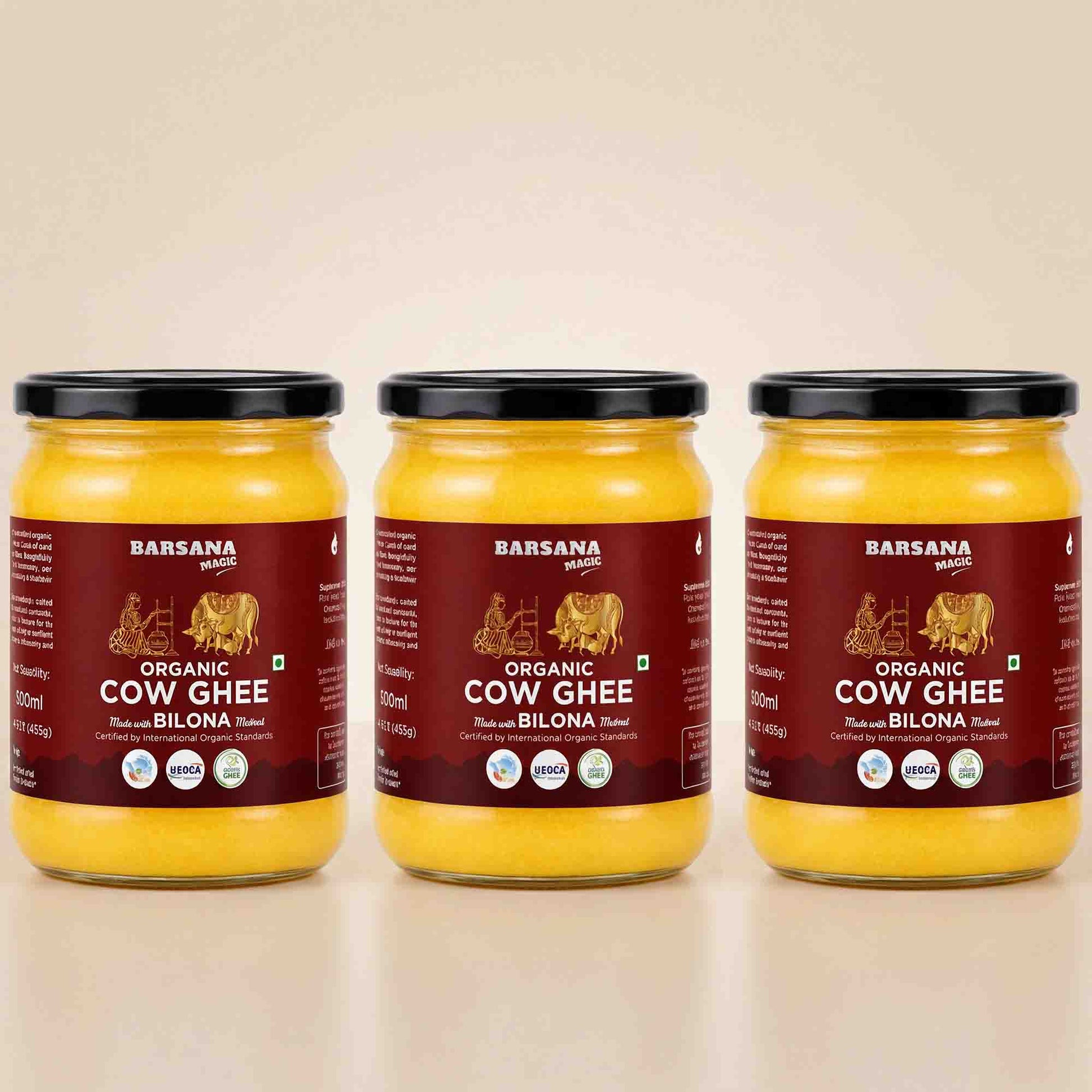 Barsana Magic and Three glass jars of Barsana Organic Cow Ghee (Rashmi and Bilona flavor) arranged side-by-side on a light beige reflective surface against a matching beige background.