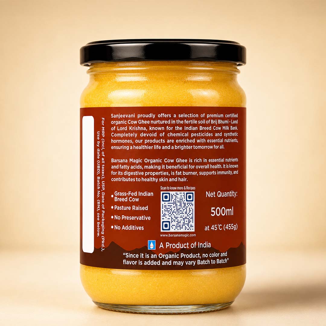 Barsana Magic and A 500ml glass jar of Barasee Magic Organic Cow Ghee, showing the back label with product details, a QR code, and the Sanskrit phrase 'Since it is an Organic Product, no color and flavor is added and may vary Batch to Batch!' against a warm beige background.