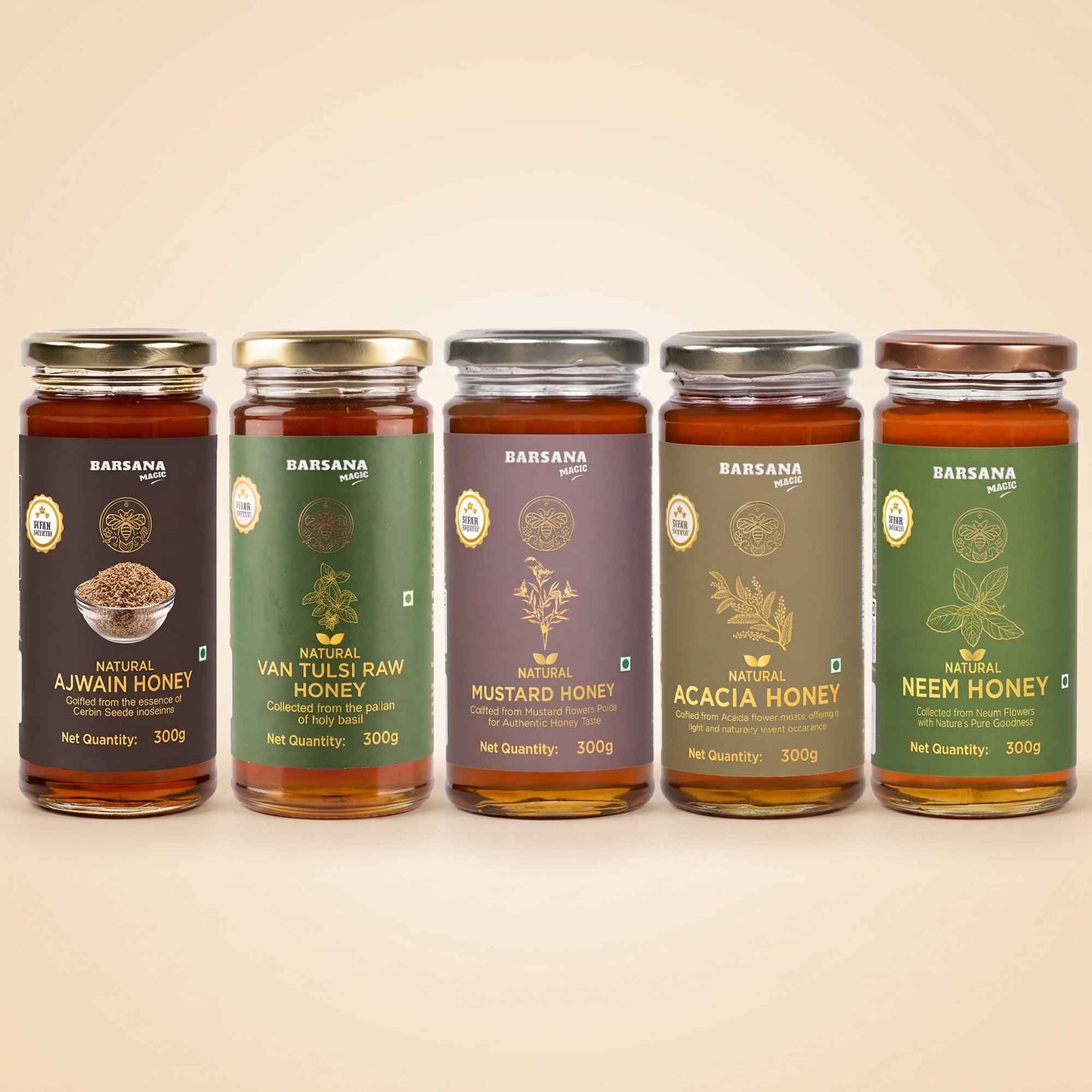 Barsana Magic and Five glass jars of BARANSA natural honey in different flavors and colors, lined up in a row against a warm beige background. The jars feature dark brown, green, purple, olive green, and dark green labels with gold lettering.