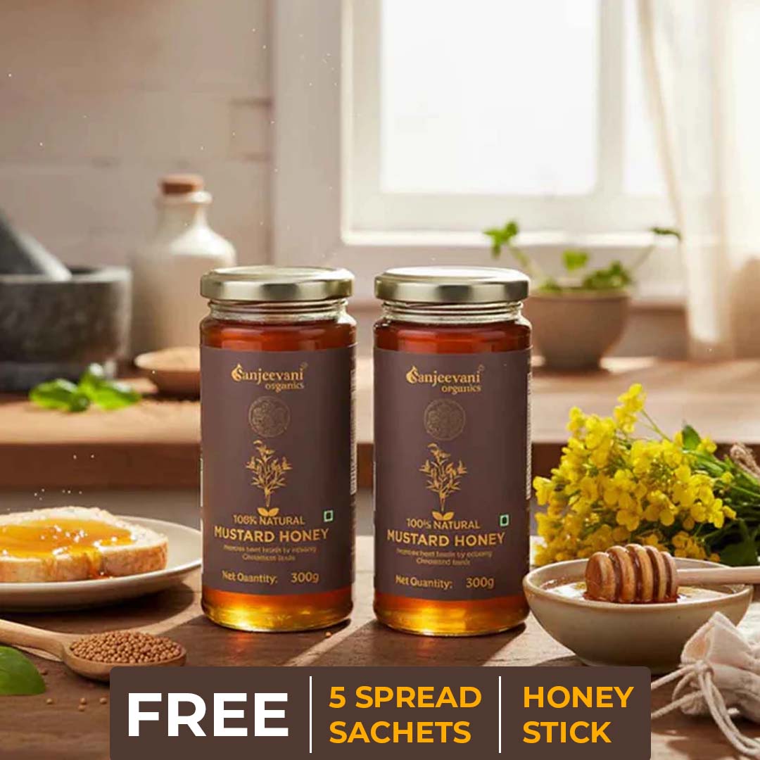 Barsana Magic and Two jars of Sanjeevani Organics mustard honey on a wooden table with kitchen items in the background.