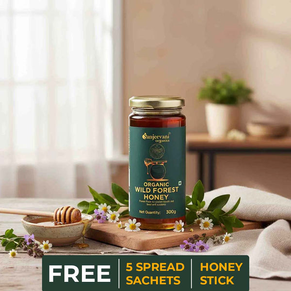 Barsana Magic and Jar of organic wild forest honey with a free spread sachets and honey stick offer on a wooden table.