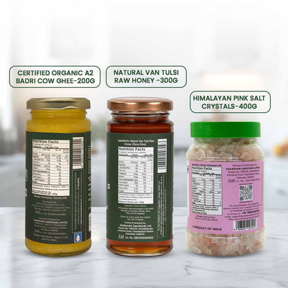 Barsana Magic and Three jars with labels for organic ghee, raw honey, and pink salt crystals on a white background.