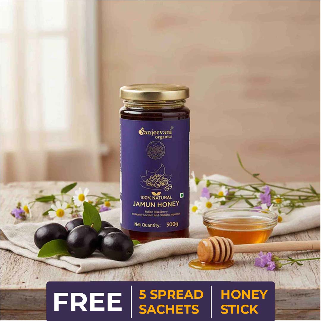 Barsana Magic and Jar of Sanjeevani Organics Jamun Honey with olives and flowers on a wooden surface