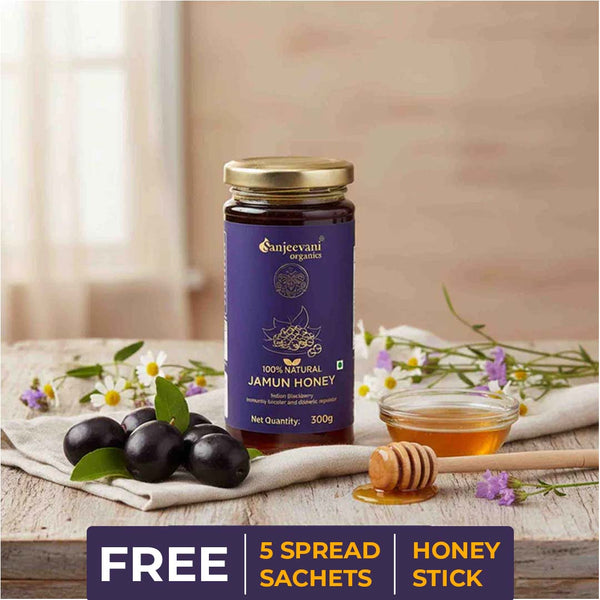Barsana Magic and Jar of Sanjeevani Organics Jamun Honey with olives and flowers on a wooden surface