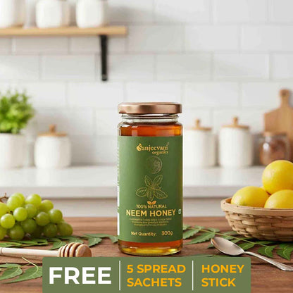Barsana Magic and Jar of Sanjeevani Neem Honey on a kitchen counter with fruits and utensils in the background.