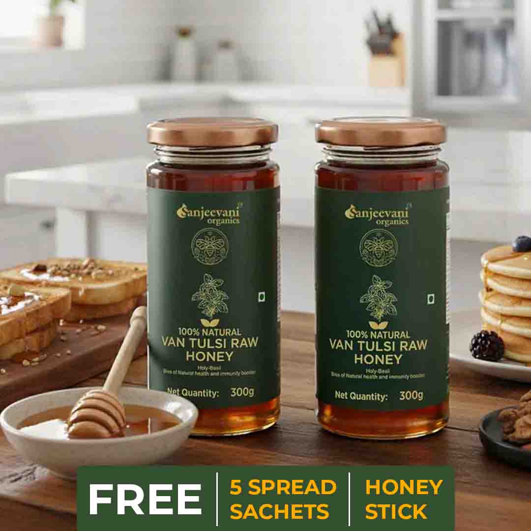 Barsana Magic and Two jars of Van Tulsi Raw Honey on a kitchen counter with a bowl of honey and a spread stick.