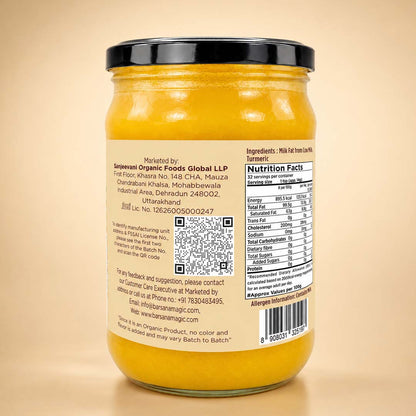 Barsana Magic and A glass jar of yellow ghee with a black lid, showing the back label with ingredients, nutrition facts, and a QR code, set against a warm beige background.
