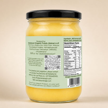 Barsana Magic and A glass jar of yellow butter with a black lid, showing the back label with text, a QR code, and nutrition facts against a plain beige background.