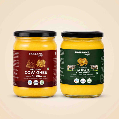 Barsana Magic and Two glass jars of Barsana Magic cow ghee on a light beige background. The left jar has a maroon label for Organic Cow Ghee and the right jar has a dark green label for Organic A2 Badri Cow Ghee, both filled with yellow ghee and topped with black lids.