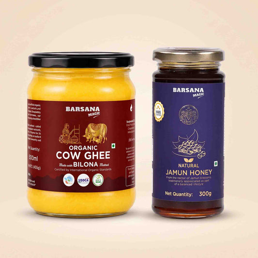 Barsana Magic and Two jars of Barsana brand food products on a light beige background: a large jar of Organic Cow Ghee with a black lid and dark red label, and a smaller jar of Natural Jamun Honey with a silver lid and dark blue label.