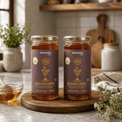 Barsana Magic and Two jars of Mustard Honey on a wooden board with a kitchen background.