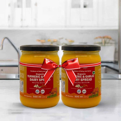 Barsana Magic and Two jars of organic dairy spread with red ribbons on a kitchen counter.