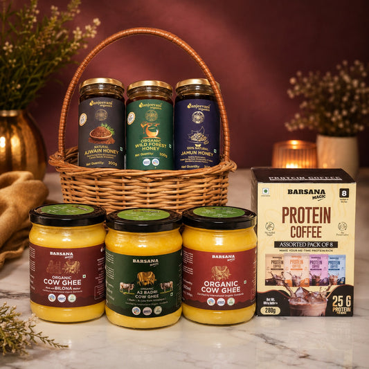 Barsana Magic and Assorted jars of cow ghee and honey with a box of protein coffee on a marble surface.