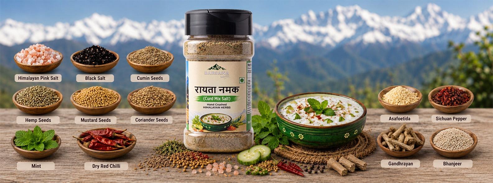 Barsana Magic and A jar of Raita Namak  displayed on a rustic wooden table with various spices, herbs, and a bowl of chutney in front of a scenic mountain backdrop. The jar features a black lid and a white label with Hindi text.