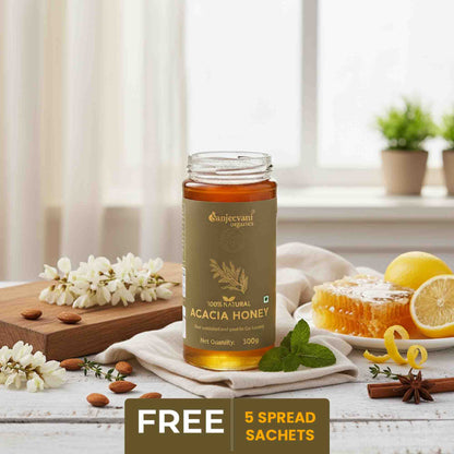 Barsana Magic and  Bottle of Sanjeevani Acacia Honey on a table with lemons, flowers, and a window in the background.