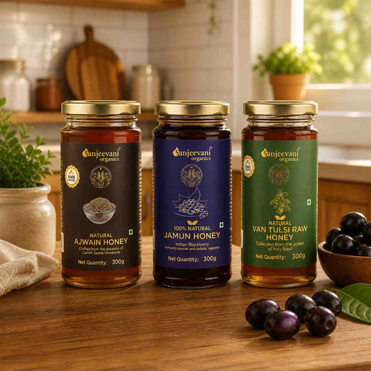 Barsana Magic and Three jars of Sanjeevani Organics honey on a wooden table with fruits and kitchen items in the background.