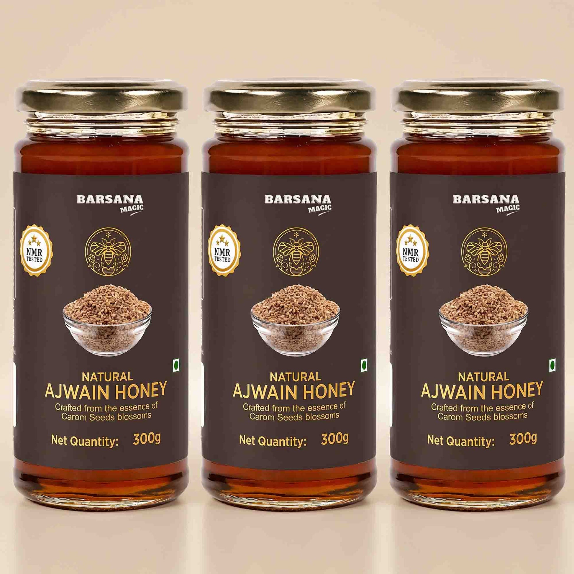 Barsana Magic and Three glass jars of Barsana Natural Ajwain Honey arranged side by side on a light beige background. Each jar has a dark brown label with gold lettering, a photo of ajwain seeds in a bowl, and a gold cap.