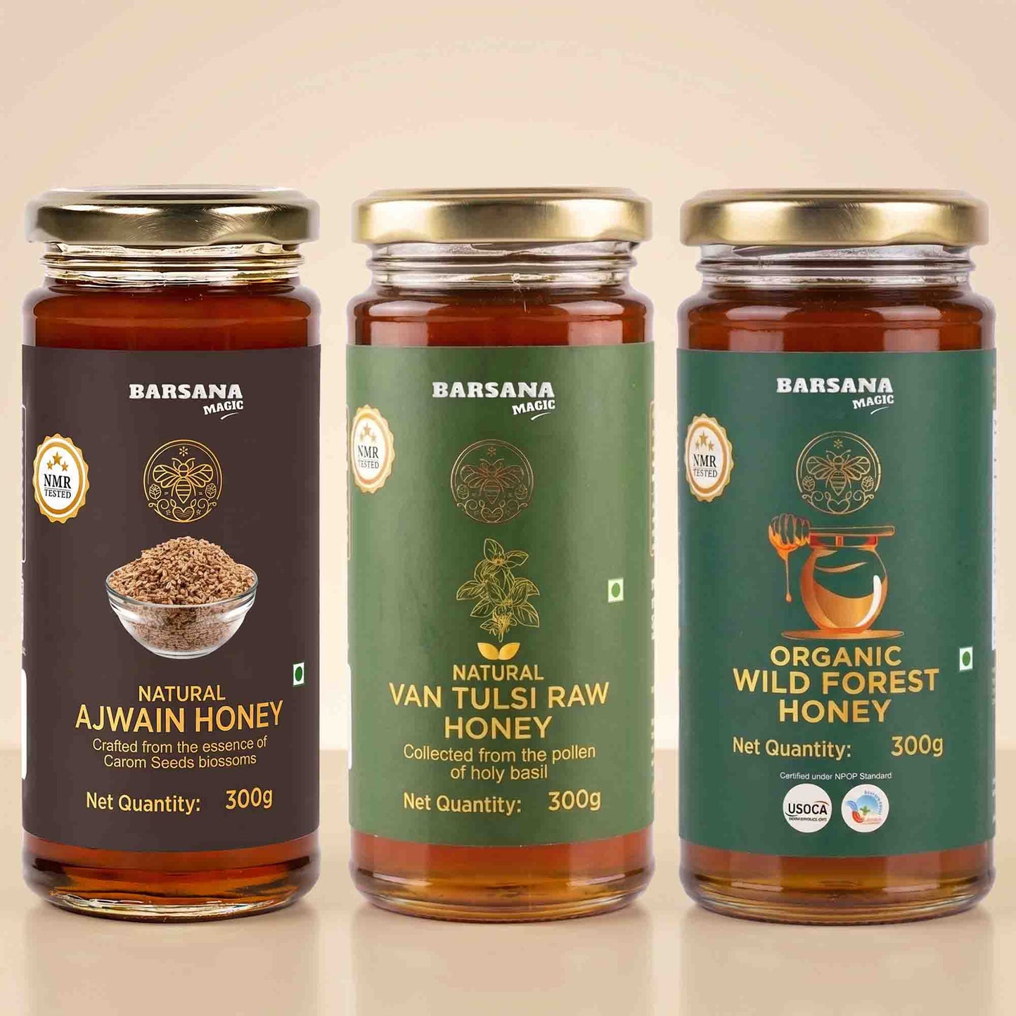 Barsana Magic and Three jars of Barsana Magic honey arranged side by side on a light beige background. The left jar is labeled Natural Ajwain Honey with a dark brown label and gold lid.