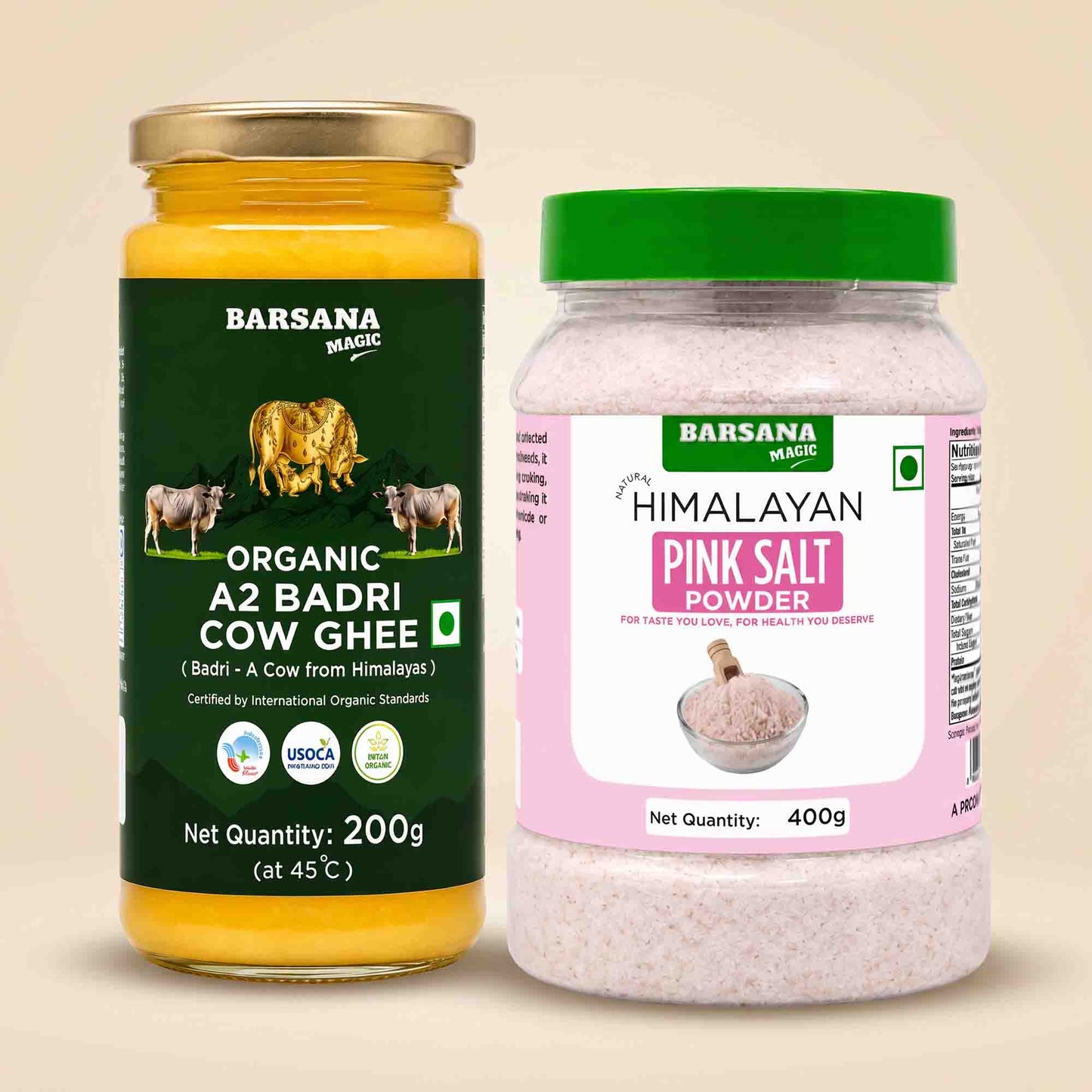 Barsana Magic and Two Barsana Magic products shown side by side on a light beige background: a 200g jar of Organic A2 Badri Cow Ghee with a gold lid and dark green label, and a 400g jar of Himalayan Pink Salt Powder with a green lid and pink label.