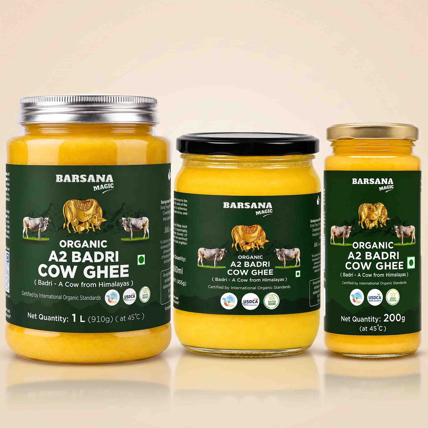 Barsana Magic and Three jars of Barsana Organic A2 Badri Cow Ghee arranged together on a light beige background. The left jar has a silver lid, the middle jar has a black lid, and the right jar has a gold lid.