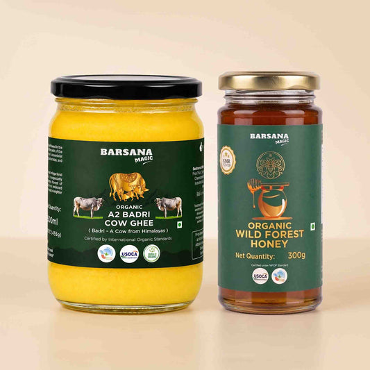 Barsana Magic and Two glass jars of Barsana Magic organic ghee and honey on a light beige background. The left jar contains yellow Az Badri cow ghee with a black lid and dark green label.