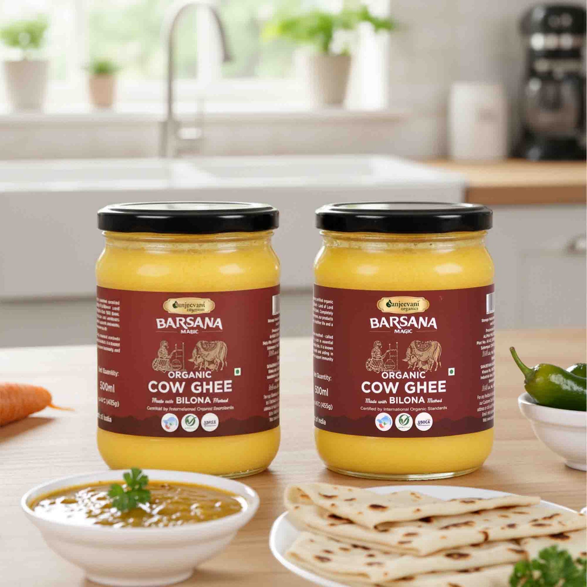 Barsana Magic and Two jars of Organic Cow Ghee on a kitchen counter with food items.