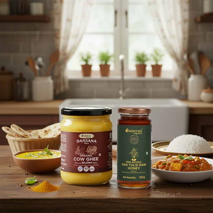 Barsana Magic and Two jars of food products on a kitchen counter with a window and plants in the background.