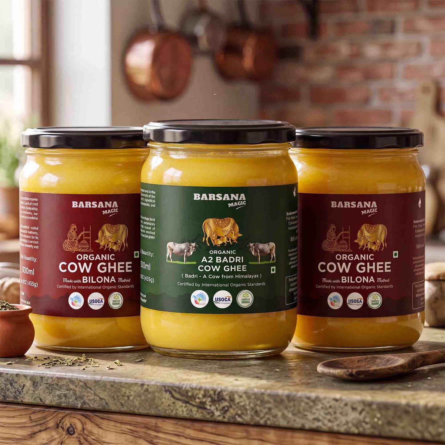 Barsana Magic and Three jars of Barsana Organic Cow Ghee arranged on a wooden countertop in a kitchen setting, with a brick wall and hanging copper pots in the background.