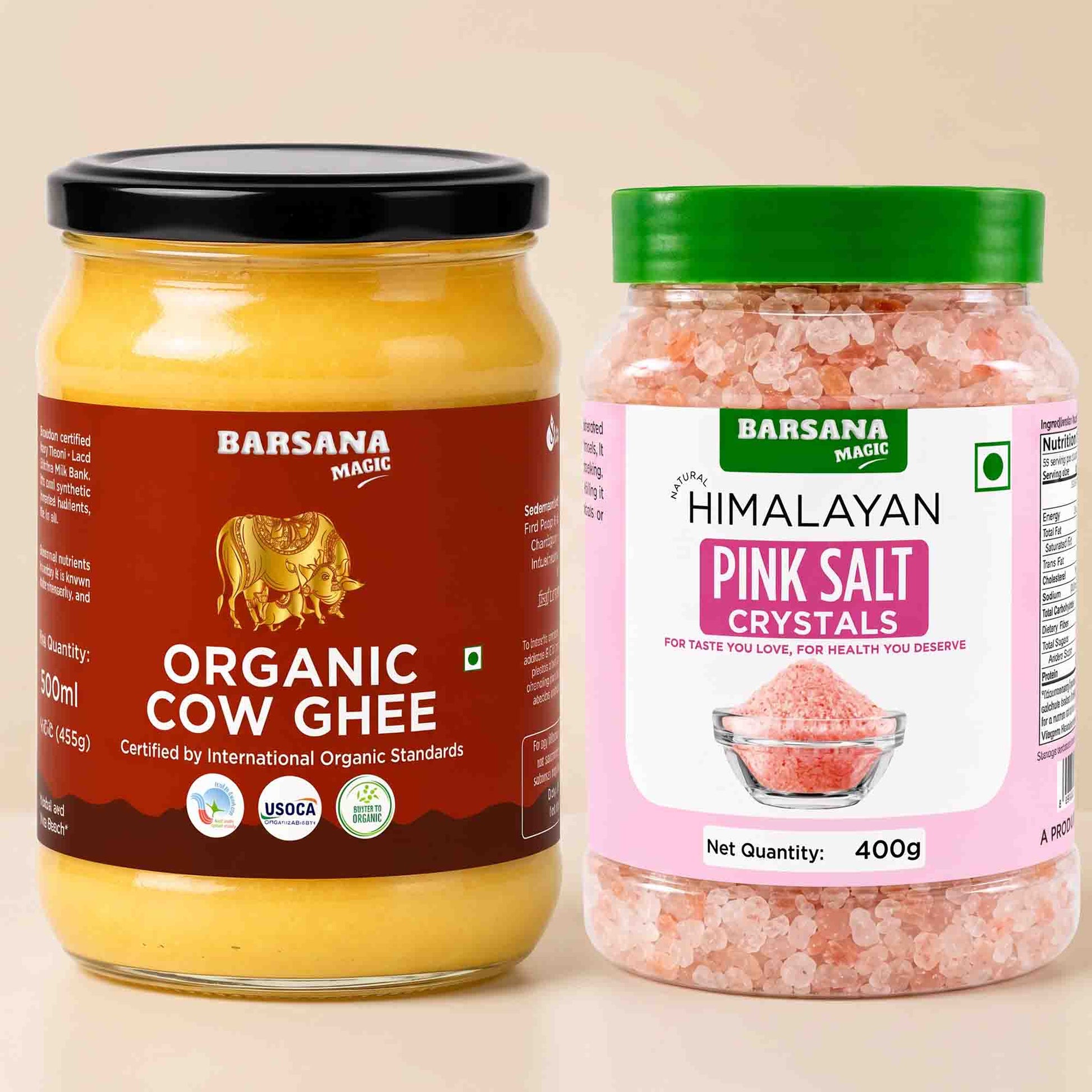 Barsana Magic and Two Barsana Magic products shown side by side on a light beige background: a glass jar of Organic Cow Ghee with a black lid and dark red label, and a plastic jar of Himalayan Pink Salt Crystals with a green lid and pink label.