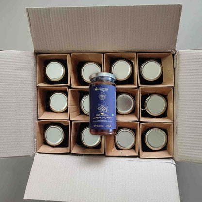 Barsana Magic and Jars of honey arranged in a cardboard box with a jar of honey on top.