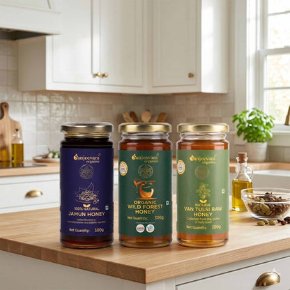 Barsana Magic and Three jars of Sanjeevani honey on a kitchen counter with cabinets and window in the background.