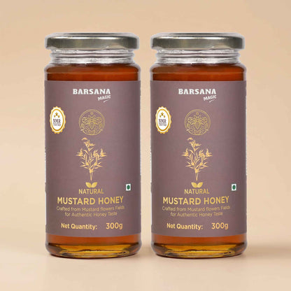 Barsana Magic and Two glass jars of Barsana Brand Natural Mustard Honey with dark brown labels and silver lids, set against a solid beige background.
