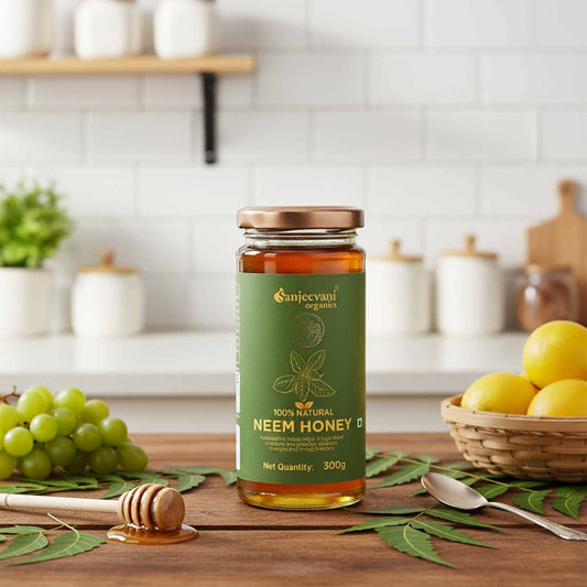 Barsana Magic and Jar of Sanjeevani Neem Honey on a kitchen counter with lemons and grapes.