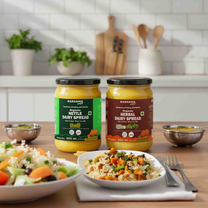 Barsana Magic and Two jars of dairy spreads on a kitchen counter with plates of food.