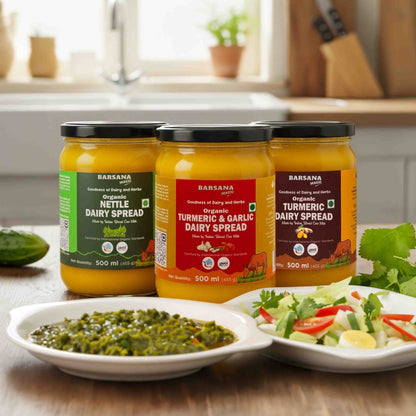 Barsana Magic and Three jars of Barsana dairy spreads on a kitchen counter with plates of food.