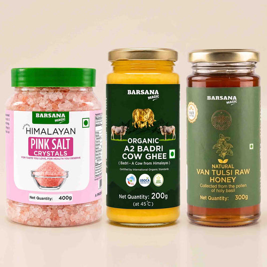 Barsana Magic and Three Barsana Magic products displayed side-by-side on a light beige background: Himalayan Pink Salt Crystals in a clear jar with a green lid, Organic A2 Badri Cow Ghee in a glass jar with a dark green label, and Natural Van Tulsi Raw Honey in a glass jar with a gold lid.
