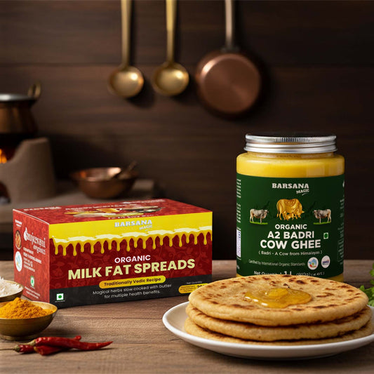 Barsana Magic and organic milk fat spreads and ghee jar on a wooden table with traditional Indian food items.