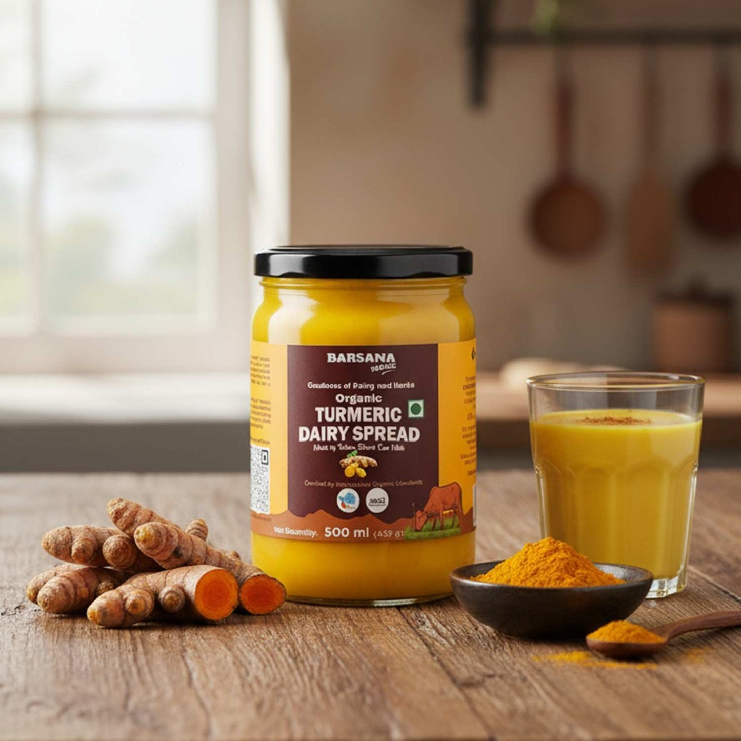 Barsana Magic and Jar of Turmeric Dairy Spread on a wooden table with turmeric roots and a glass of juice.