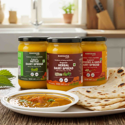 Barsana Magic and  Three jars of dairy spreads with a bowl of curry and flatbread on a kitchen counter.