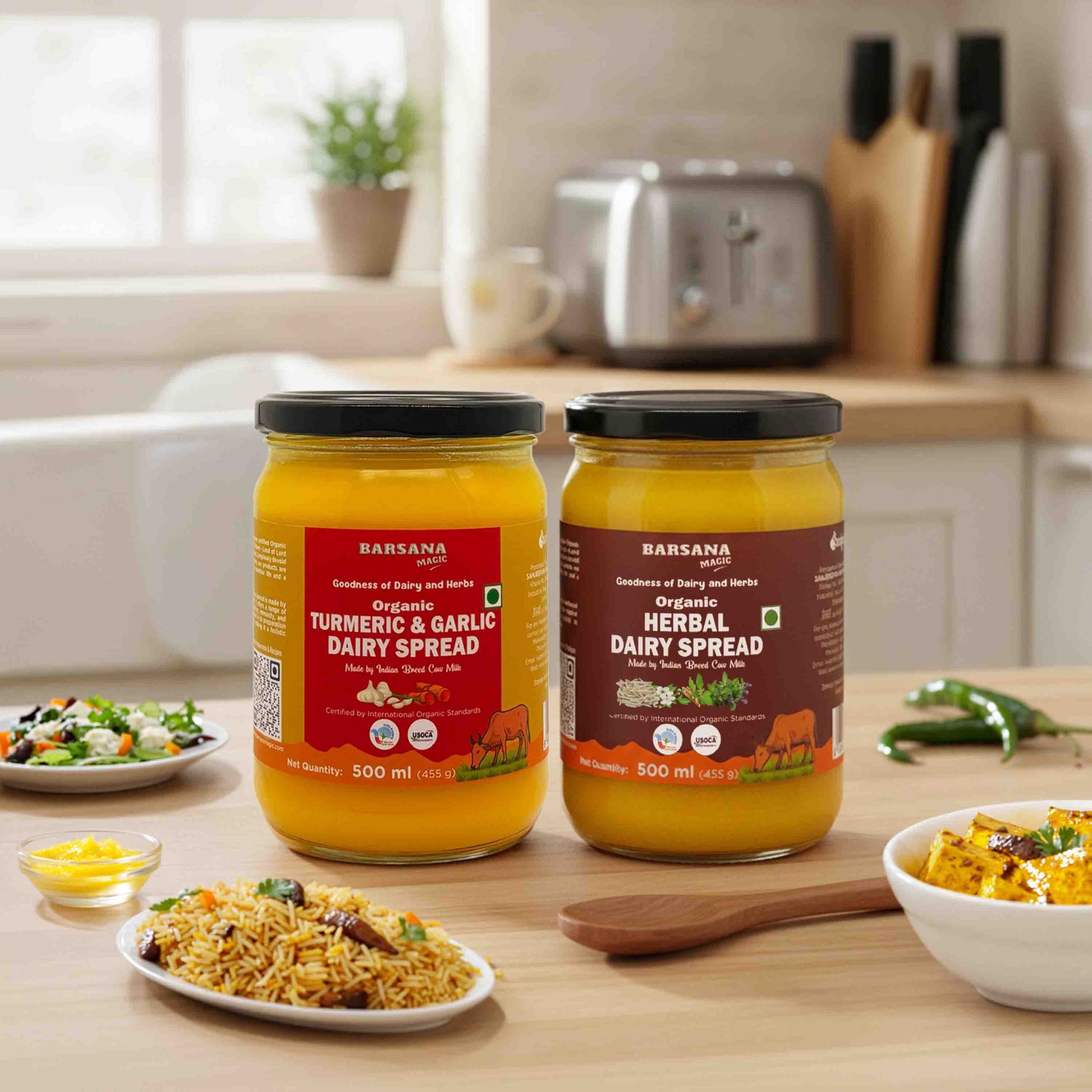 Barsana Magic and  Two jars of dairy spreads on a kitchen counter with food items around.