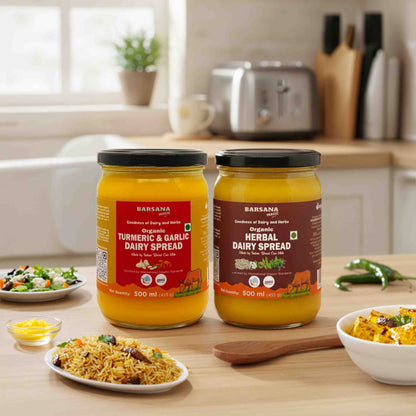 Barsana Magic and  Two jars of dairy spreads on a kitchen counter with food items around.