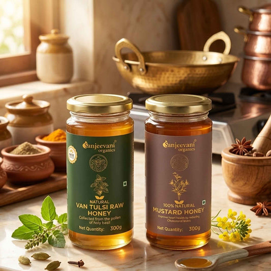 Barsana Magic and Two jars of Sanjeevani Organics honey on a kitchen counter with copper pots and spices in the background.