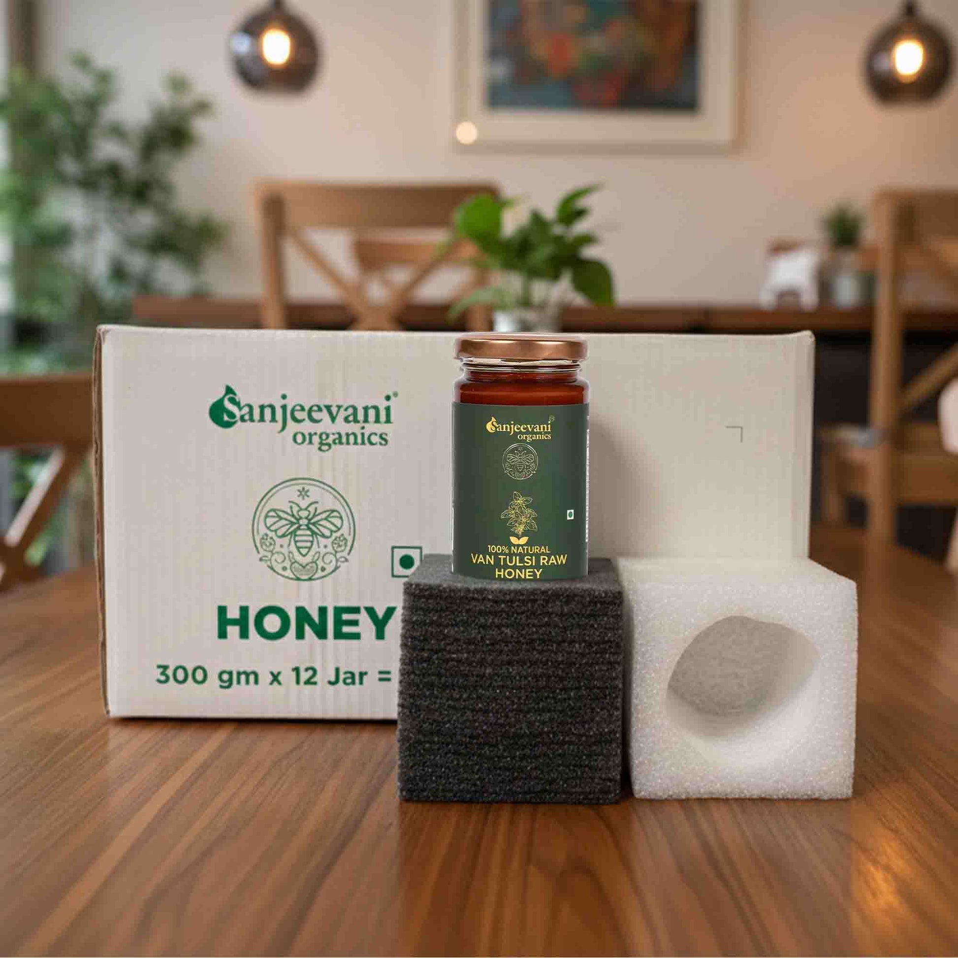 Barsana Magic and Organics honey jar and packaging on a wooden table with a blurred background