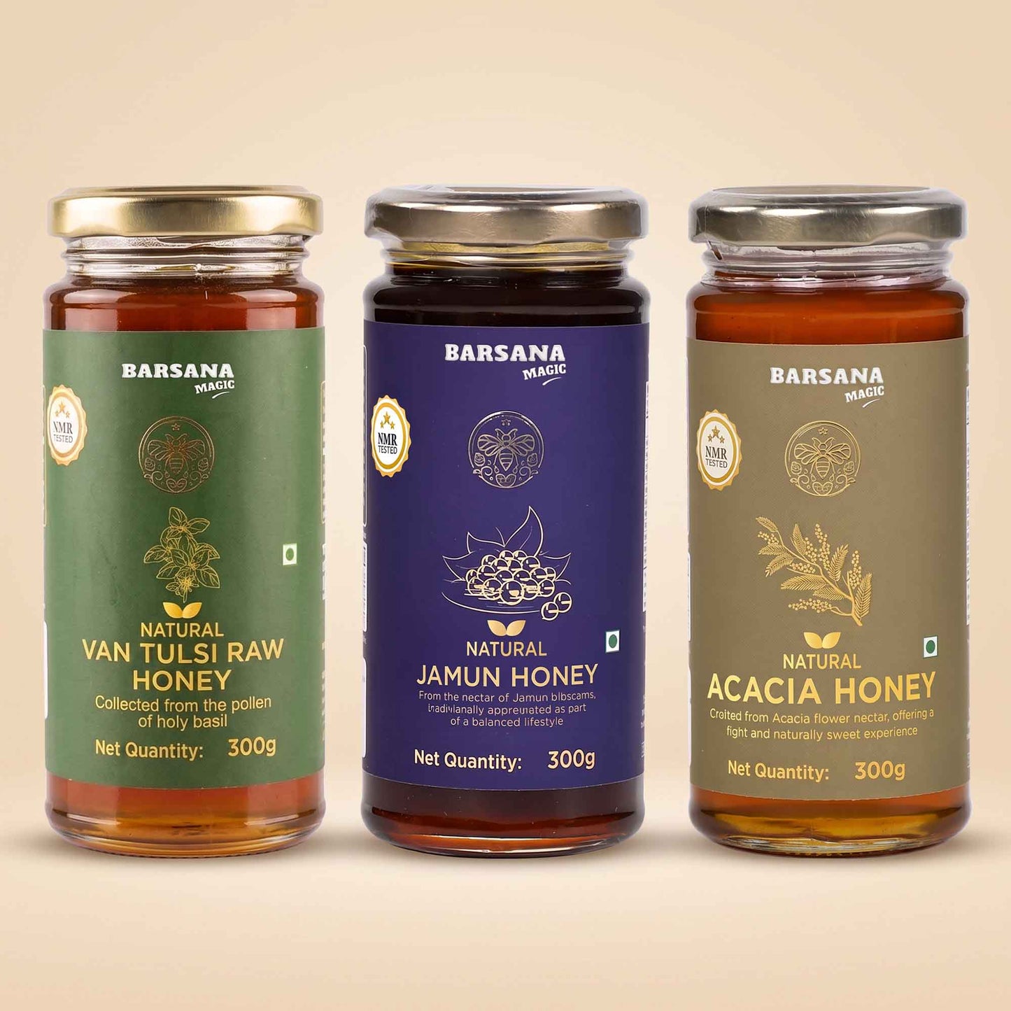 Barsana Magic and Three glass jars of Barsana Magic natural honey lined up against a solid beige background. From left to right, the labels are green for Van Tulsi Raw Honey, dark purple for Jamun Honey, and olive green for Acacia Honey.